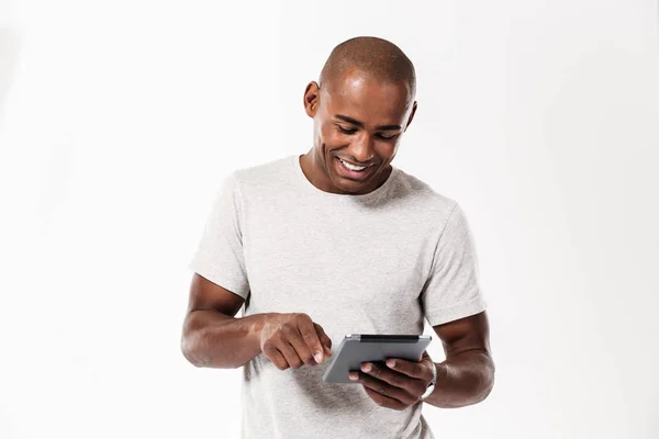 Feliz joven africano hombre usando tableta ordenador . —  Fotos de Stock