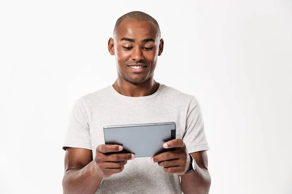 Lachende Afrikaanse man met behulp van tablet pc — Stockfoto