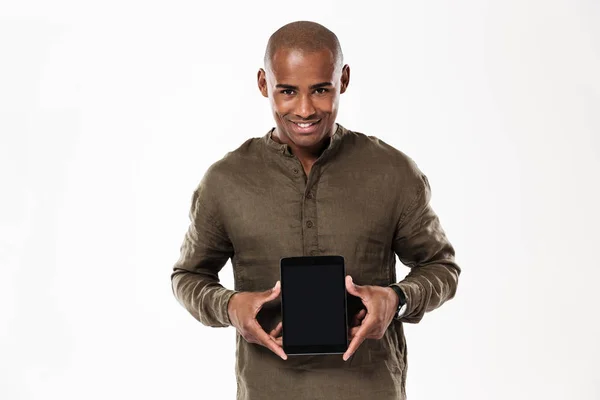 Sonriente hombre africano mostrando la pantalla de la tableta en blanco —  Fotos de Stock