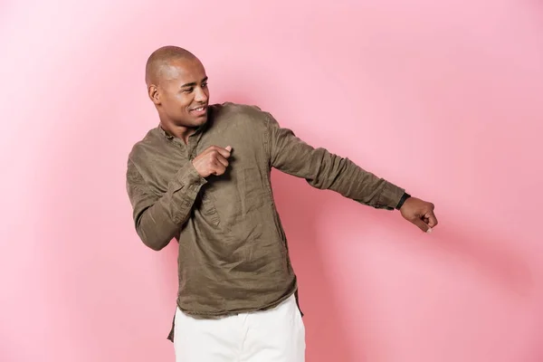 Despreocupado hombre africano bailando en el estudio y mirando hacia otro lado —  Fotos de Stock