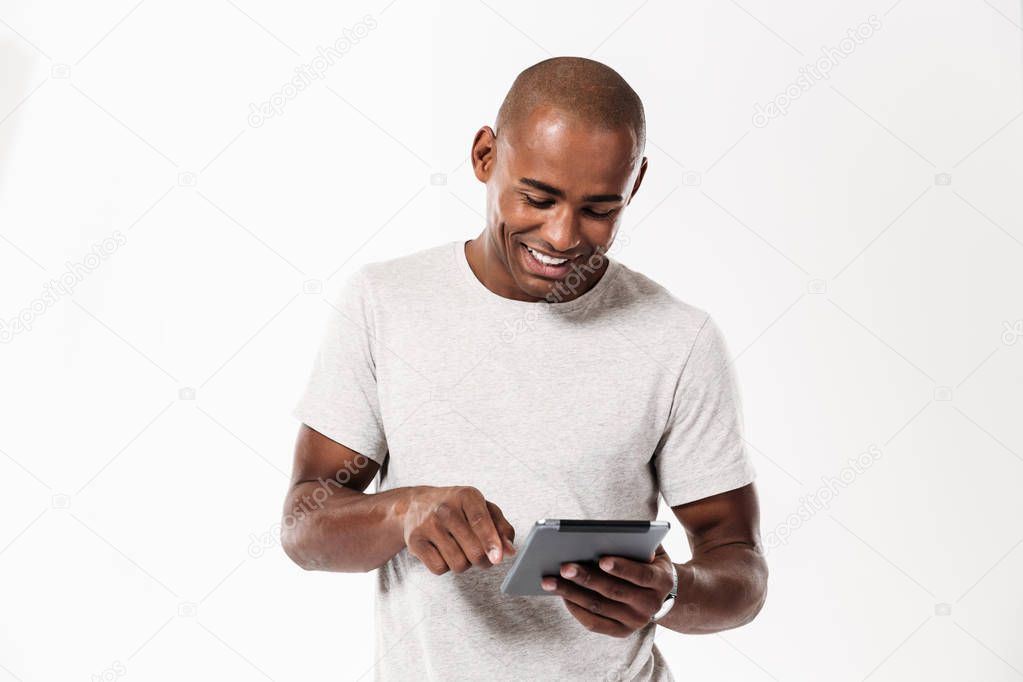 Happy young african man using tablet computer.