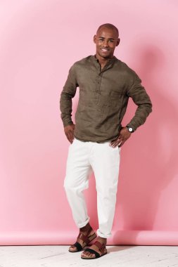 Tam uzunlukta görüntü gülümseyen Afrikalı adamın kalçalarına silah tutan