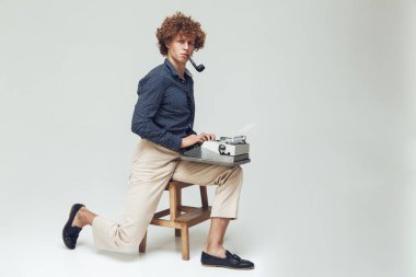 Daktilo tutan boru ile ciddi retro adam.