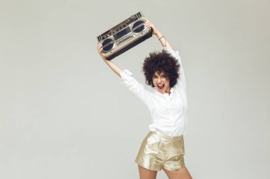 Boombox tutan gömlek giymiş duygusal retro kadın.