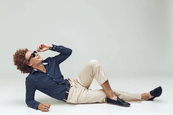 Handsome young retro man dressed in shirt lies on floor — Stock Photo, Image