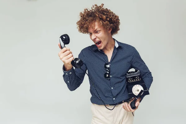 Screaming angry retro man with telephone in hands. — Stock Photo, Image