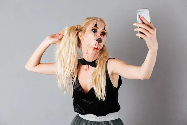 Sorglösa blond kvinna i halloween utgör att göra selfie — Stockfoto