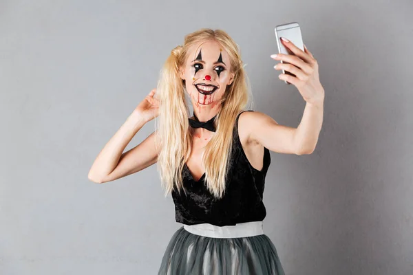 Leende blond kvinna i halloween smink att göra selfie — Stockfoto