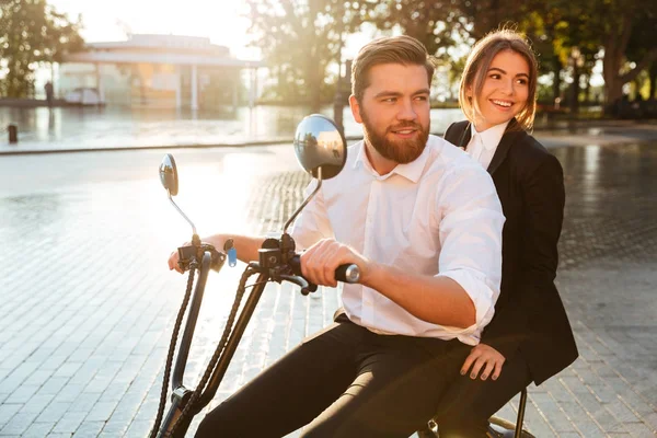 Seitenansicht eines lächelnden Geschäftspaares fährt auf modernem Motorrad — Stockfoto