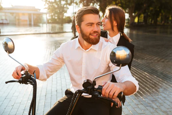 Unbekümmertes Geschäftspaar fährt mit modernem Motorrad im Park — Stockfoto