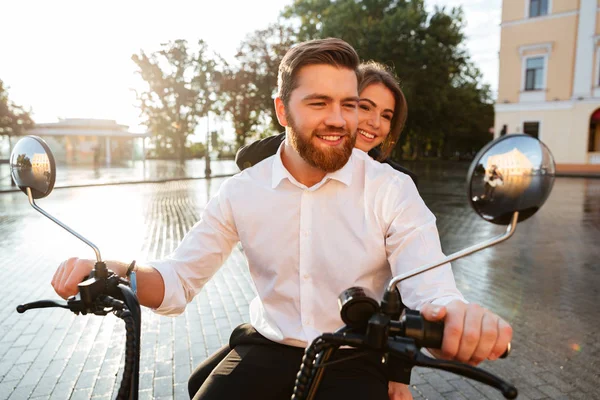 Feliz pareja de negocios paseos en moto moderna en el parque —  Fotos de Stock