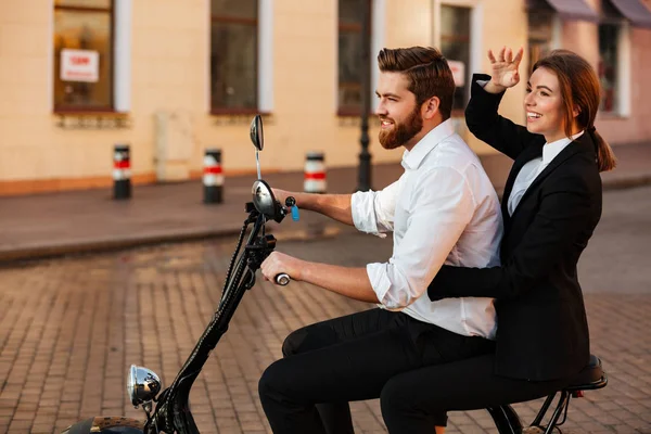 Side view of pleased business couple rides on modern motorbike — Stock Photo, Image