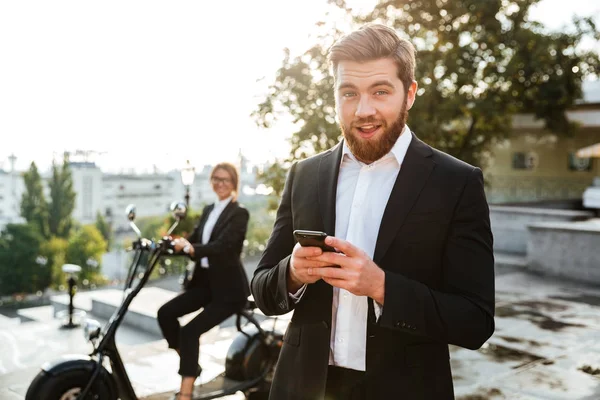 Geschäftsmann posiert mit Smartphone im Freien — Stockfoto