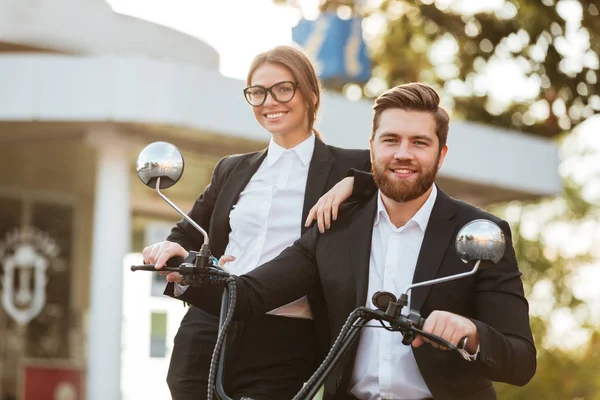 Glückliches Geschäftspaar posiert mit modernem Motorrad im Freien — Stockfoto