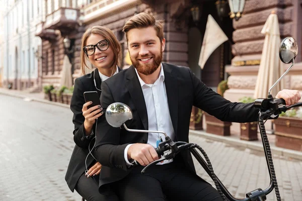 Happy stylish couple rides on modern motorbike outdoors — Stock Photo, Image
