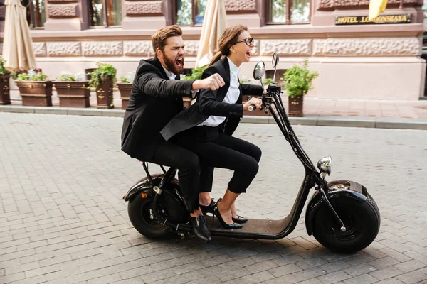 Glückliches aufgeregtes Paar in schicker Kleidung beim Motorradfahren — Stockfoto