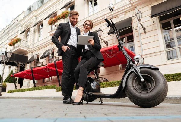 Bild von glücklichem Businesspaar, das in der Nähe von Motorrad posiert — Stockfoto