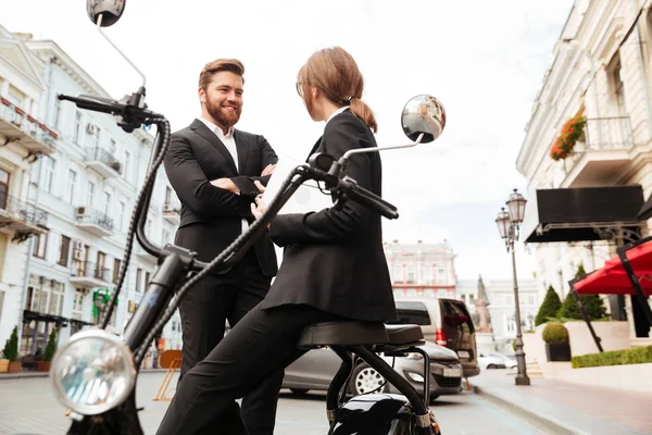 Glückliches Geschäftspaar posiert in der Nähe des modernen Motorrads im Freien — Stockfoto