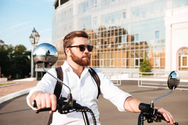 Serin sakallı adam sırt çantası ile güneş gözlüğü rides — Stok fotoğraf