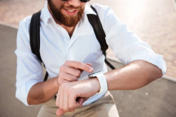 Przycięte Zamknij się obraz uśmiechający się Brodaty mężczyzna przy użyciu zegarek na rękę — Zdjęcie stockowe