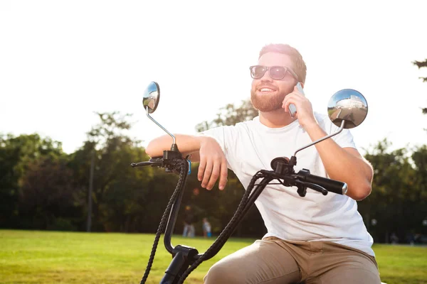 Uśmiechający się Brodaty mężczyzna w siedzi na motocykl nowoczesny okulary przeciwsłoneczne — Zdjęcie stockowe