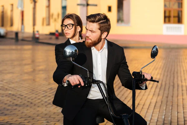 Vorsichtiges Geschäftspaar fährt mit modernem Motorrad in Park — Stockfoto