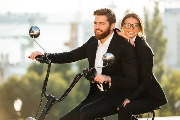 Seitenansicht von lächelndem Paar in Anzügen fährt Motorrad — Stockfoto