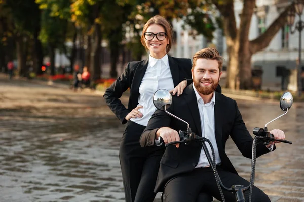 Lächelndes Geschäftspaar posiert mit modernem Motorrad im Freien — Stockfoto