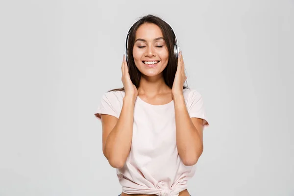 Retrato de um feliz satisfeito asiático mulher em fones de ouvido — Fotografia de Stock