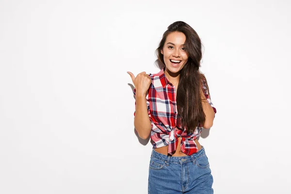 Mladá hezká dívka v kostkované košili ukazuje palcem nahoru — Stock fotografie