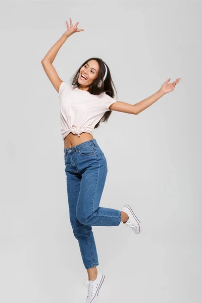 Comprimento total retrato de uma mulher asiática feliz em fones de ouvido — Fotografia de Stock