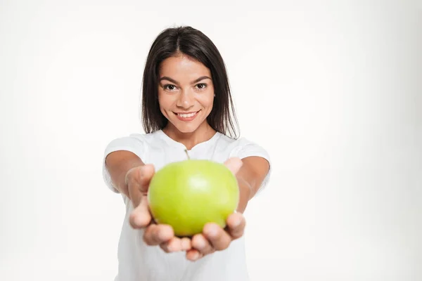 Portret van een lachende gezonde vrouw tonen van groene appel — Stockfoto