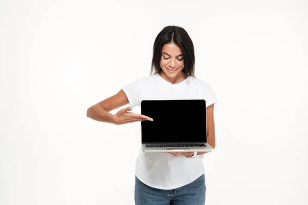 Retrato de una bonita mujer joven que presenta una computadora portátil de pantalla en blanco —  Fotos de Stock