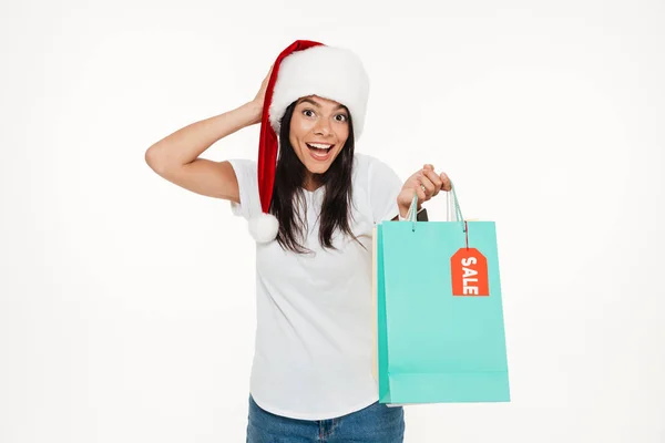 Portrét šťastné brunetka žena v červené vánoční čepice — Stock fotografie