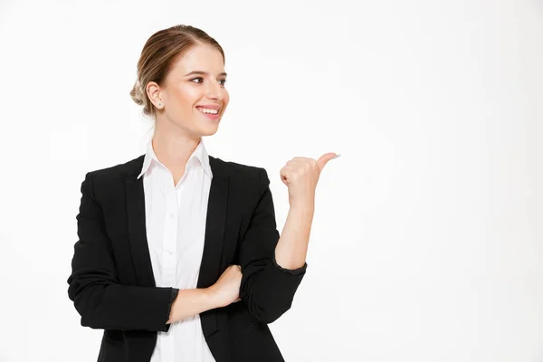 Lächelnde blonde Geschäftsfrau, die wegschaut und wegzeigt — Stockfoto