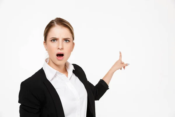 Shocked blonde business woman pointing back and looking at camera — Stock Photo, Image