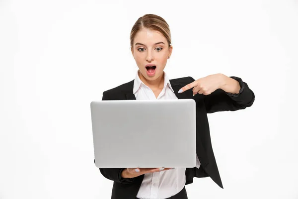 Shocked blonde business woman holding laptop computer — Stock Photo, Image