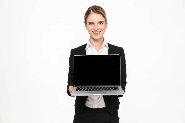 Lächelnde blonde Geschäftsfrau zeigt leeren Laptop-Bildschirm — Stockfoto