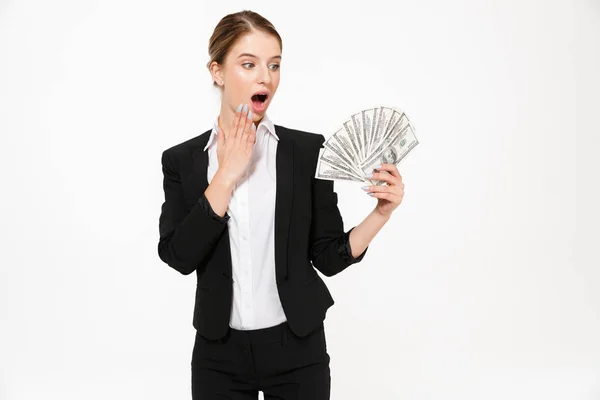 Šokovaný blond obchodní žena držící peníze a při pohledu jejich — Stock fotografie