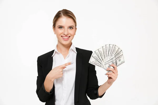Smiling blonde business woman holding money and pointing on their — Stock Photo, Image