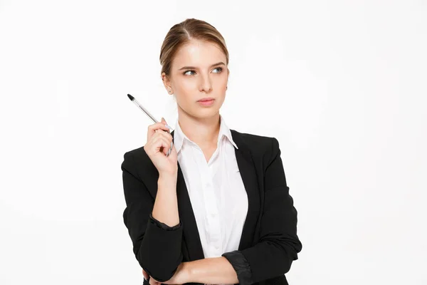 Серьезный блондинка бизнес женщина держит ручку и смотрит в сторону — стоковое фото