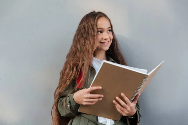 Gelukkig brunette schoolmeisje met lange haren gekleed in warme kleding — Stockfoto