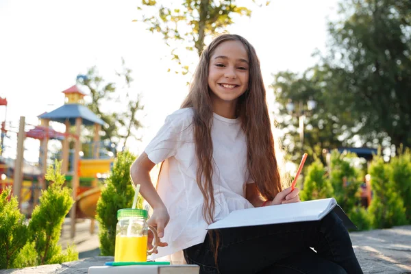 Glimlachend jong meisje buiten zitten met laptop en SAP — Stockfoto