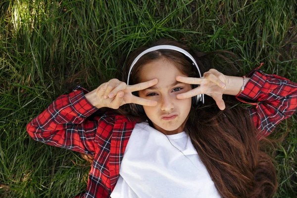 Vue du dessus de la jeune fille brune allongée sur l'herbe — Photo