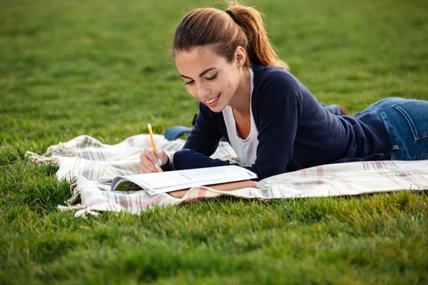 Nahaufnahme Porträt eines glücklichen Studentenmädchens beim Hausaufgabenmachen — Stockfoto