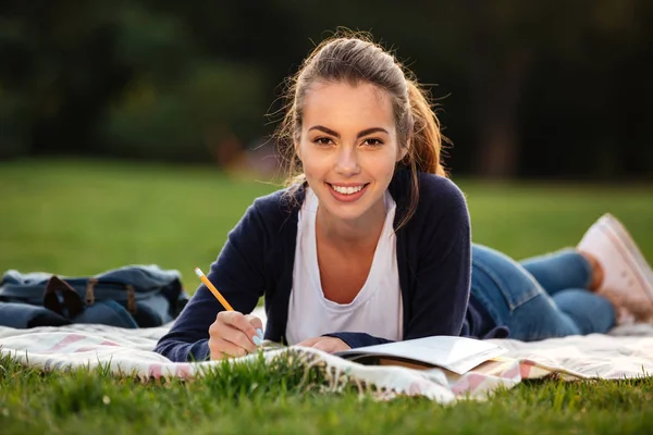 Close up portrait of a happy student girl doing homework — Stock Photo, Image