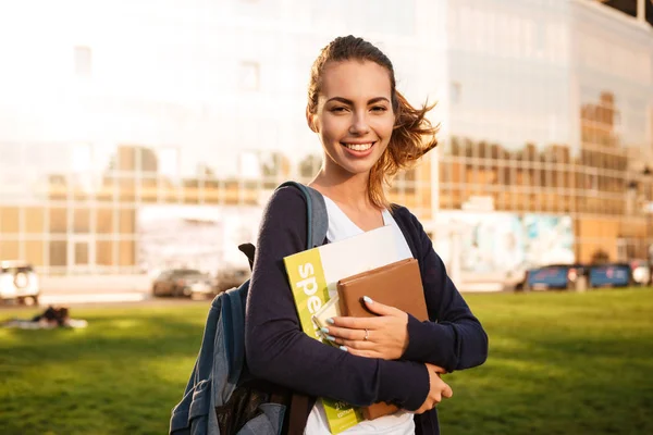 Portret van een meisje van de vreugdevolle bruinharige student permanent — Stockfoto