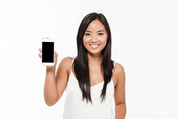 Retrato de uma mulher asiática mostrando telefone celular tela em branco — Fotografia de Stock