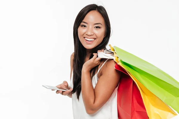 Retrato de una mujer asiática atractiva feliz sosteniendo teléfono móvil — Foto de Stock