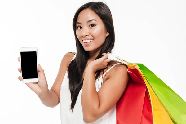 Sorrindo jovem asiático mulher mostrando branco tela celular — Fotografia de Stock